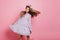 Blissful european girl in purple dress fooling around in studio. Joyful white woman with flowers in hair dancing on