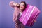 Blissful european woman in pink outfit holding sparkle present box. Laughing curly girl posing on p