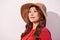 Blissful lady with broad smile posing in sunny day. Laughing girl in red clothes and trendy straw hat enjoying good weather in