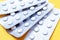 A blister pack of statins, pills tablets for lowering cholesterol on yellow background, prevention and treatment of