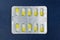 Blister or pack of ten medical tablets or pills. Dark blue background