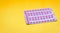 Blister packs of contraceptive pills on yellow background. Hormone pills for treatment hormone acne. Birth control pills. Estrogen