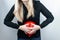 Bloating and flatulence concept. The woman holds a red balloon near the abdomen, which symbolizes bloating. Intestinal tract and d