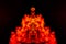 A blob of red and orange smoke in the form of a wavy pattern in the center of the frame depicting the head of a monster or an