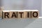 Block of alphabet letters forming the word RATIO on wooden surface. Concept of common marketing business terms. Slightly defocused