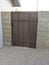 Block fence with newly installed brown wooden gate