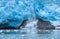 A block of ice falls off and the vertically sloped glacier tongue of Northwestern Glacier (third of four photos).