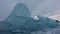 A block of large ice hummocks against the background of a cloudy sky.