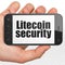 Blockchain concept: Hand Holding Smartphone with Litecoin Security on display