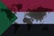 Blockchain world map on the background of the flag of Sudan and cracks. Sudan cryptocurrency concept