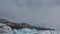 Blocks of turquoise ice hummocks on a frozen lake.