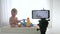 Blog about child development, cute kid boy in unfocused play with educational toys while video recording on mobile phone