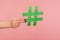 Blog marketing, social media trends. Closeup of female hand holding green hashtag sign, sharing tagged message