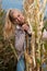 Blog style fashion photo of cute blond woman on corn field in late autumn