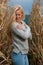 Blog style fashion photo of cute blond woman on corn field in late autumn