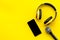 Blogger, journalist or musician work space with microphone, telephone and headphones on yellow background top view
