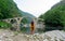 Blogger woman enjoying roman structure in Bulgaria. Devil Bridge historical monument. Fashion Girl traveler with hat on a valley.