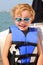 Blond 6yr old child with life jacket & sun glasses