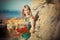Blond adoreable lady woman wearing stylish summer colourful dress posing with adoreable sensual body on sea side beach with bouque
