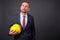 Blond bearded businessman with goatee holding hardhat against gr