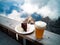 Blond beer and a slice of Sachertorte, mountains, rocks and clouds on the background