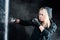 Blond boxing woman in black punching bag