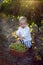 Blond boy child collects it in a basket grapes