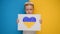 Blond boy holding banner with yellow-blue heart drawn with marker in banner. Kid will support Ukraine by showing heart