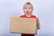 Blond boy holding big box and wondering. Surprise child with box in hands on white background