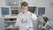 Blond boy scientist pouring liquid at laboratory