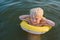 Blond boy swims with yellow floaties. Vacation sea with children