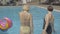 Blond and brunette Caucasian women entering outdoor swimming pool at luxurious summer resort. Back view of slim adult