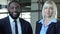 Blond businesslady and black man smiling on camera, race gender equality at work