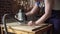 Blond carpenter works with plunge router in workshop.