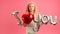 Blond Caucasian girl happy dancing holding in his hands message saying I LOVE YOU from an inflatable gel ball. Girl