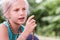 Blond caucasian girl practices meditation with rosaries outdoor summer day. yoga, mindfulness, harmony concept - girl making