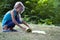 Blond caucasian girl rolling yoga mat. children`s yoga in the Park. Close-up of attractive young girl folding green yoga or