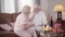 Blond Caucasian mature woman touching husband`s face, senior grey-haired man talking. Married retirees in love spending