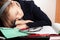 Blond Caucasian schoolgirl sleeps on the desk