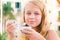 Blond Caucasian teenage girl eats frozen yogurt