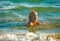 Blond child bathing in sea