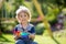 Blond child, playing with a pop up toy in the garden, antistrees silicone toy