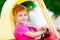 Blond children girl driving toy car