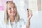 Blond dietitian holds a marker and writes on a glass board