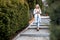 Blond dreaming confident woman, walking down alley stone stairs, fashion trendy warm white jacket, drinking coffee. City