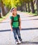 Blond explorer kid girl walking with backpack in autumn trees