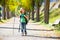 Blond explorer kid girl walking with backpack in autumn trees