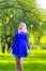 Blond Girl in Front of Falling Bunch of Daffodils Away. Posing Against Nature Background