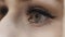 Blond girl grey eyes blinking. Black mascara and eyeliner