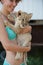Blond girl holding cute little lion cub